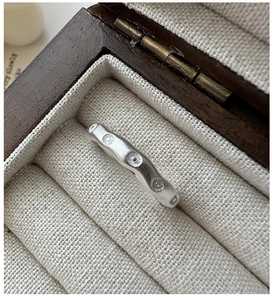 Vue macro d'une bague S925 en argent ondulé avec texture mate et motifs à pois