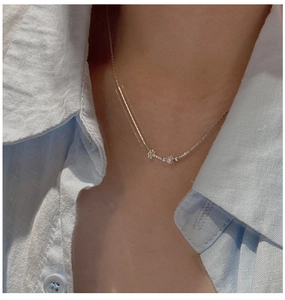 Primo piano di una collana di perline in argento sterling S925 con fiori al collo