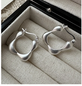 Detailed macro view of S925 silver square earrings with matte brushed finish in a jewelry box