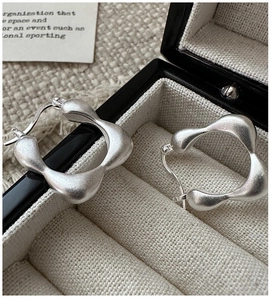 Close-up of S925 sterling silver square hoop earrings with a matte wavy finish