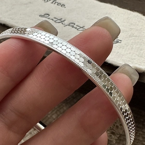 925 silver honeycomb bangle with vintage scale pattern and beaded edge worn by a model