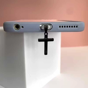 Minimalist black cross phone dust plug pendant with metallic texture on display