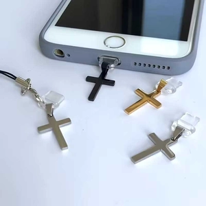 Detail of cross charms in black, gold, and silver finishes on a smartphone plug