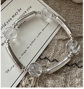 Detail of S925 silver beaded bracelet with clear crystal beads on a linen fabric background