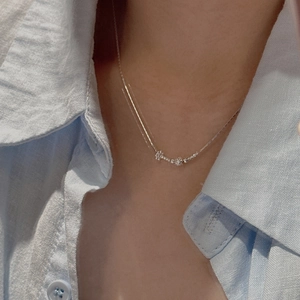 Collana delicata in argento 925 con perline e ciondolo floreale minimalista indossata