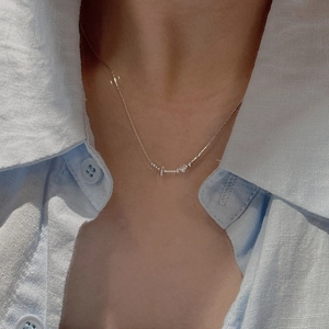 Collana di perline minimalista in argento sterling S925 da donna indossata su camicia blu