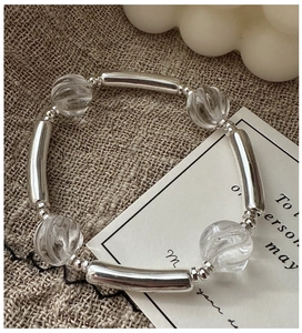 Detailed close-up of S925 sterling silver beaded bracelet with white crystals on linen