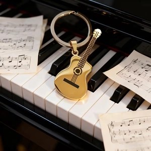 Polished gold guitar keychain on piano keys with sheet music for a musical vibe