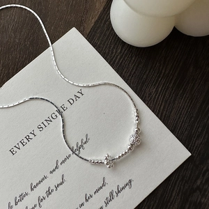 Collana minimalista in argento S925 con perline e pendente a fiore su carta crema