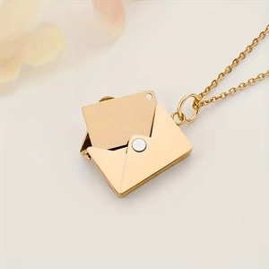 Macro view of gold envelope locket necklace with movable hidden photo compartment