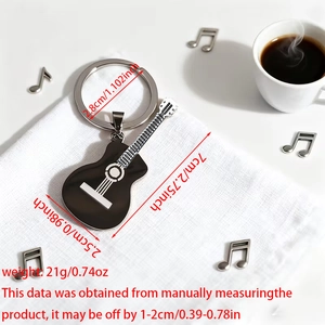 Guitar keychain dimensions showing 7cm length and 21g weight on white fabric background