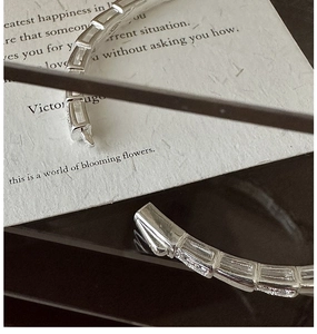 Macro view of silver geometric link bracelet with baguette-cut crystal embellishments