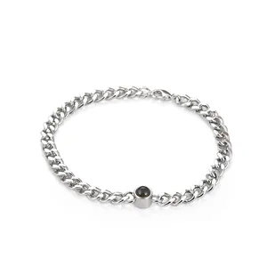 Macro view of silver stainless steel curb chain bracelet with custom projection stone