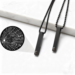 Dettaglio macro della collana a barra nera con pietra di proiezione Ti amo in 100 lingue