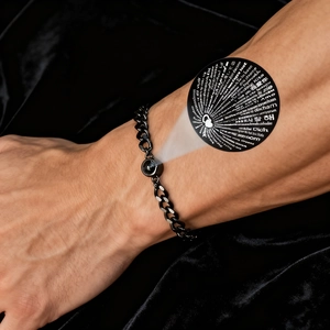 Detail of black stainless steel Cuban chain bracelet with 100 languages projection stone