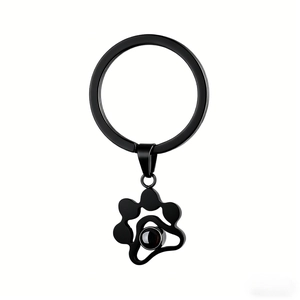 Detail of black cat paw projection stone pendant on a matte metal keychain ring
