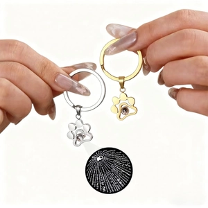 Cat paw projection keychain set in gold and silver showing I Love You in 100 languages