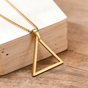 Gros plan du pendentif triangle doré minimaliste sur chaîne fine et bois