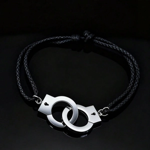 Unisex hip hop leather rope bracelet with silver handcuffs on a reflective black surface