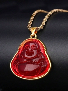 Close-up of a red laughing Buddha pendant with golden rope chain on black background