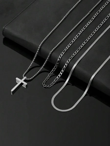 Detailed close-up of stainless steel layered necklace set with cross pendant on black base