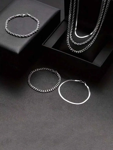Detail shot of assorted silver stainless steel jewelry chains on black matte gift boxes
