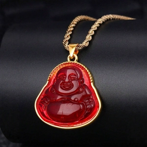 Laughing Buddha necklace with red translucent pendant and gold twisted chain on stand
