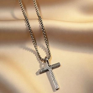 Collana con croce in argento e intarsio di zirconi su sfondo di seta color champagne