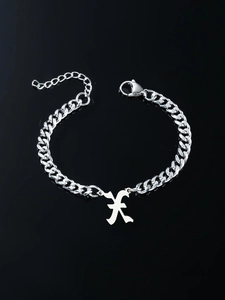 Detailed close-up of a silver Gothic letter K pendant on a trendy Cuban link chain bracelet