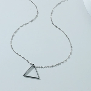 Gros plan d'une chaîne argentée avec pendentif triangle noir sur fond bleu clair