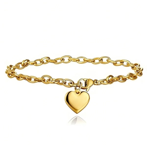 Détail du bracelet avec pendentif cœur doré, chaîne à maillons en O et fermoir mousqueton