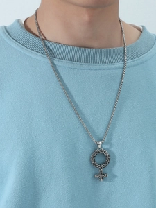 Close-up of vintage silver Venus symbol pendant with textured finish on square pearl chain