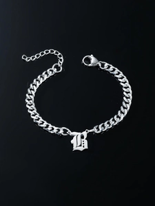 Detailed shot of silver gothic letter B pendant on a flat Cuban chain bracelet with clasp