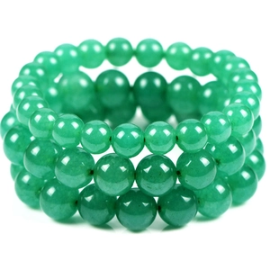 Close-up of three layered green round gemstone bead bracelets on white background