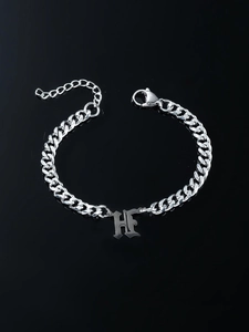 Macro detail of gothic H letter pendant on silver curb chain with lobster clasp