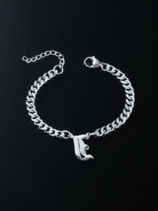 Polished silver Cuban link bracelet with Gothic letter E pendant on black reflective background