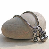 Detailed macro view of stainless steel boxing glove pendant on a silver metal chain link