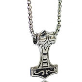 Detailed close-up of a silver Mjolnir Thor hammer pendant with antique Viking carvings