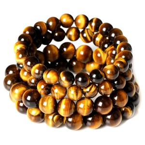 Macro shot of polished tiger eye beaded bracelets with shimmering golden brown cat eye effect