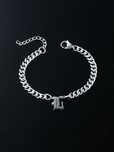 Detailed shot of silver gothic letter L pendant on a Cuban link chain bracelet