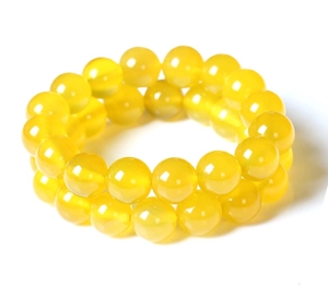 Close-up of polished yellow agate beaded bracelets showing smooth texture and luster