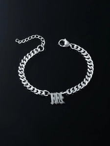 Silver Cuban chain bracelet with Gothic initial pendant on reflective black surface