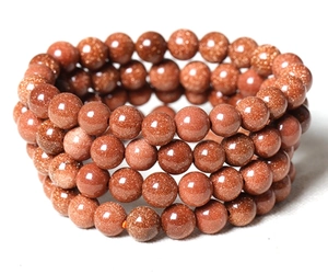 Macro detail of multi-layer goldstone bead bracelet with sparkling copper flakes
