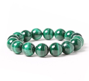 Macro view of polished green malachite stone beads with natural striped patterns
