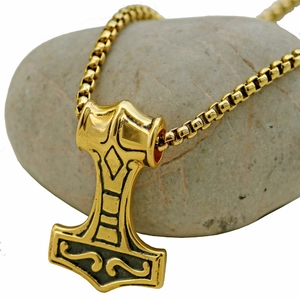 Vintage gold stainless steel Thor Hammer necklace with Mjölnir pendant on a pebble