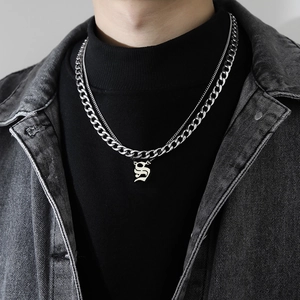 Vue macro d'un collier double chaîne cubaine avec pendentif lettre S gothique homme