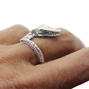 Detailed view of an adjustable vintage silver crocodile ring worn on a person's finger
