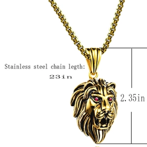 Détail du pendentif tête de lion vintage doré avec yeux rouges et chaîne maille box