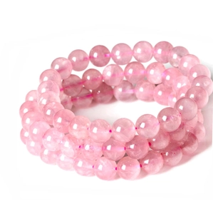 Macro shot of three natural rose quartz beaded bracelets with translucent pink finish