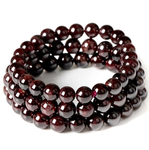 Detailed macro view of triple-layered deep red garnet beaded bracelet with high polish finish